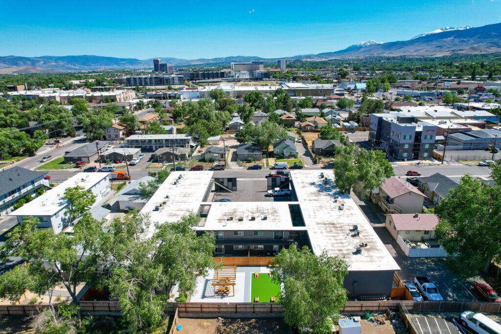 An aerial view of a city with a large building in the middle of it.
