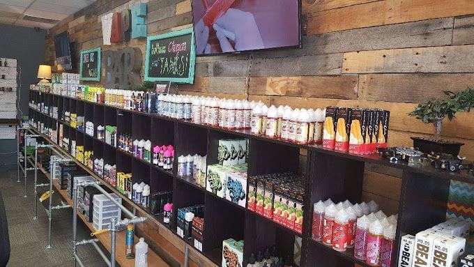 A store filled with lots of shelves filled with bottles of e liquid.