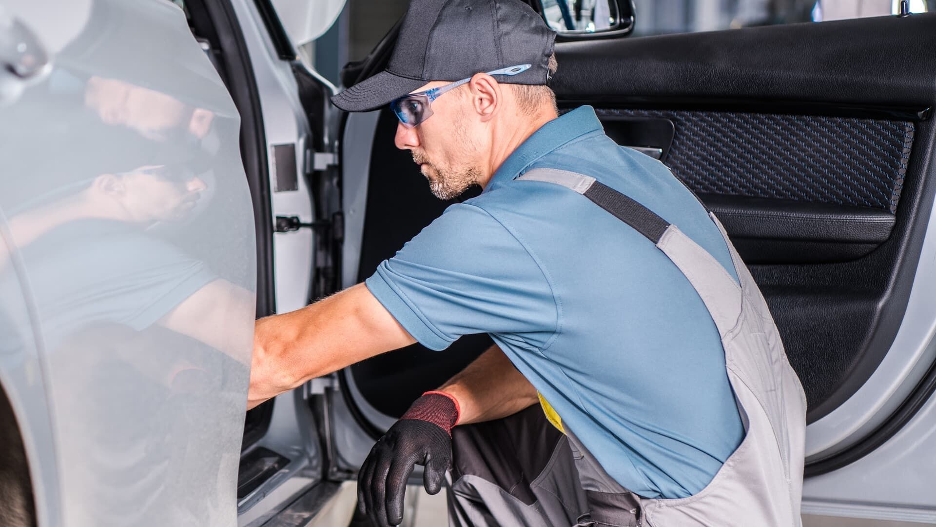 A man is working on the inside of a car.