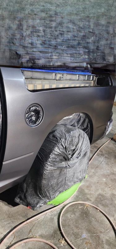 A car is sitting in a garage covered in a tarp.