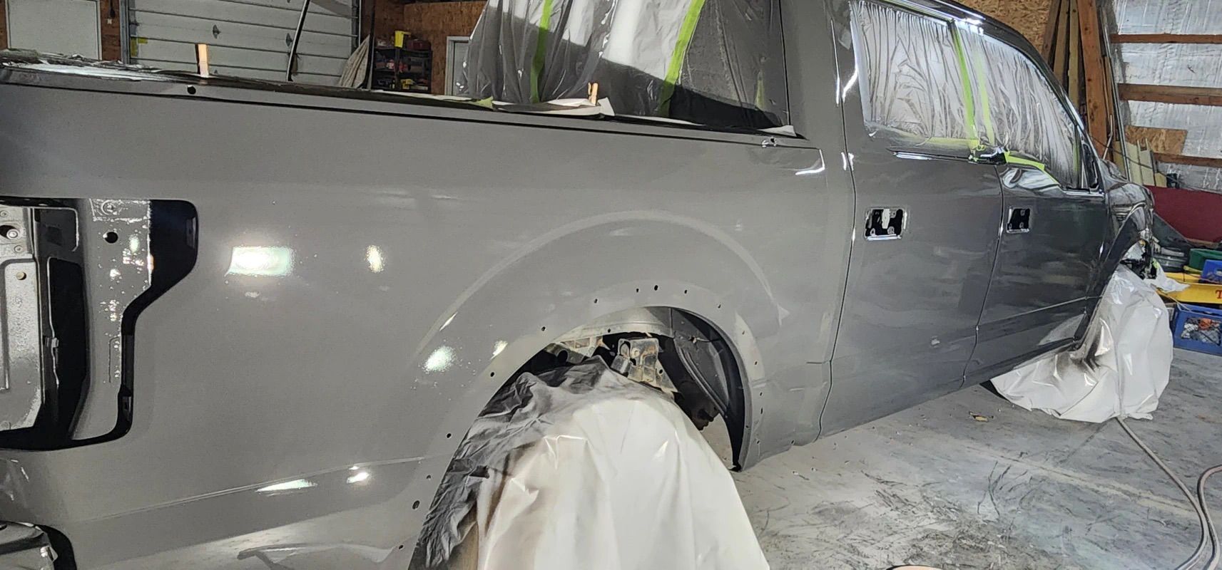 A gray truck is sitting in a garage covered in foam.