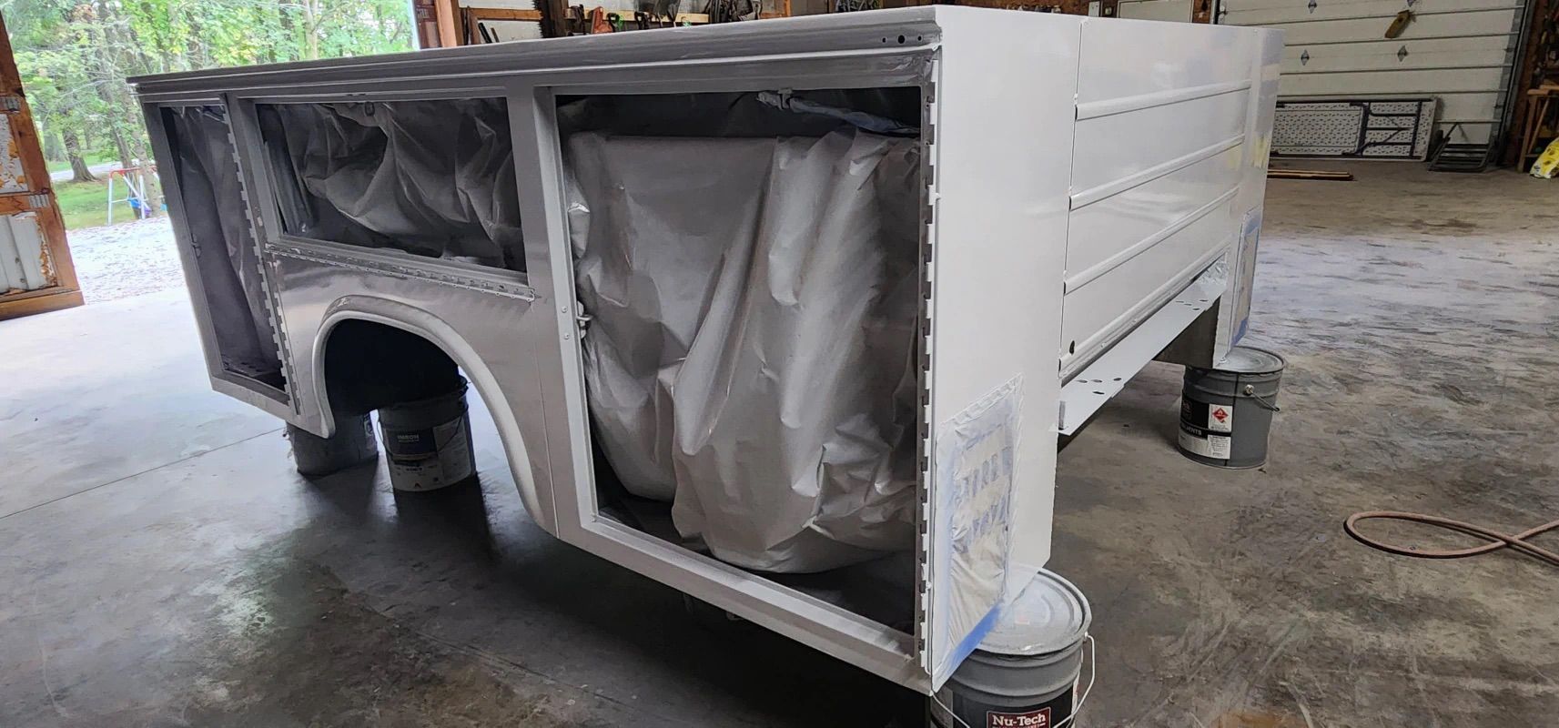 A white box is sitting on top of a concrete floor in a garage.