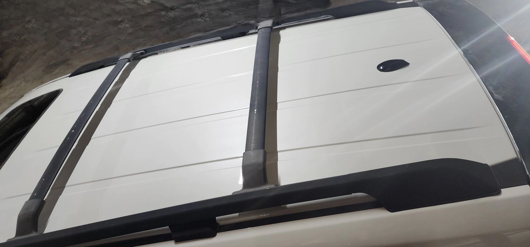 A white car with a black roof rack on it