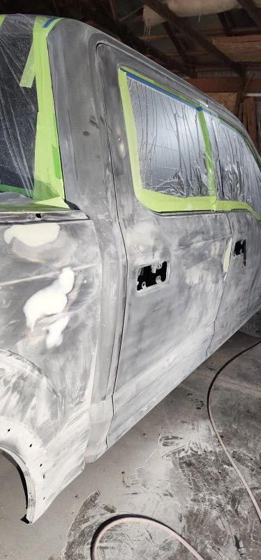 A car is being painted in a garage.