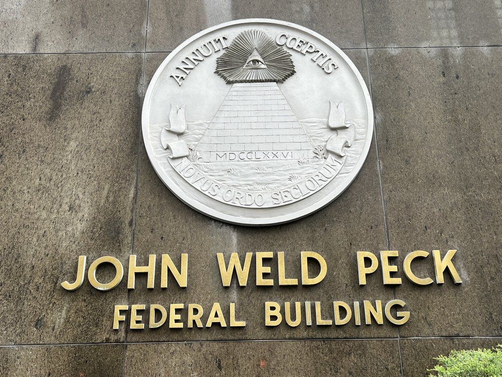 John Weld Peck Federal Building with seal of the United States. Gold lettering on brown stone.