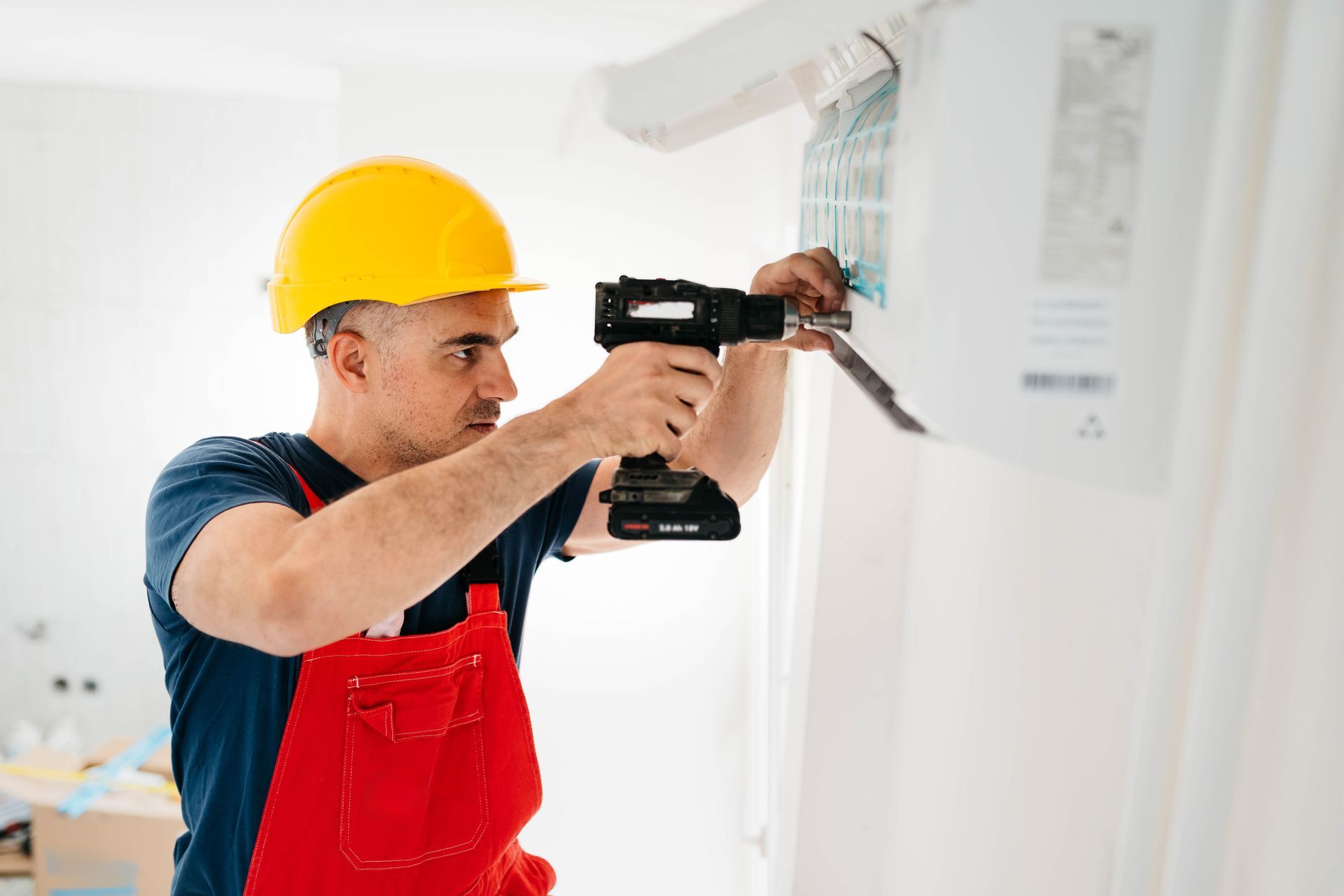 Man with a helmet installing air conditioner.