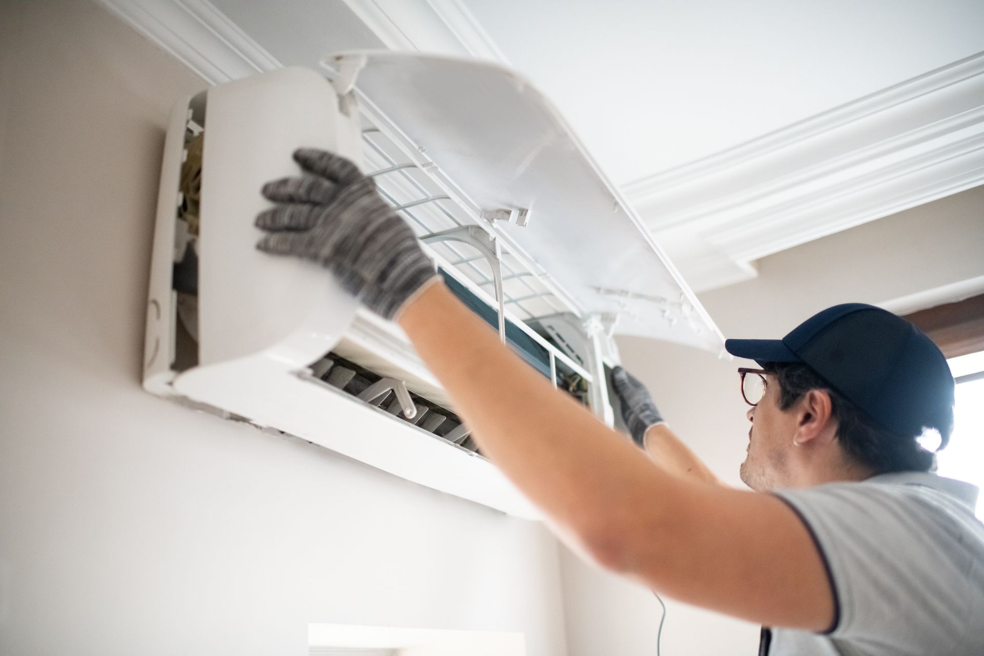 A technician is checking an AC unit.