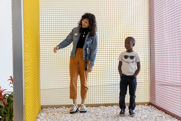 A woman and a boy are standing next to each other in a room.