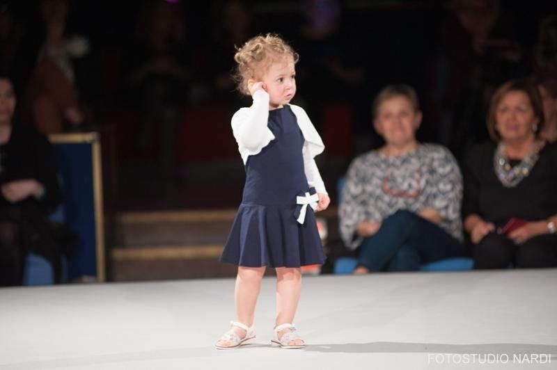 bambina con vestito nero e copri spalle bianco
