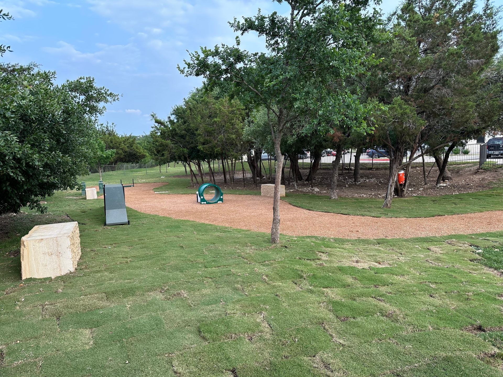 A dog park with a slide and a ring in the middle of it.