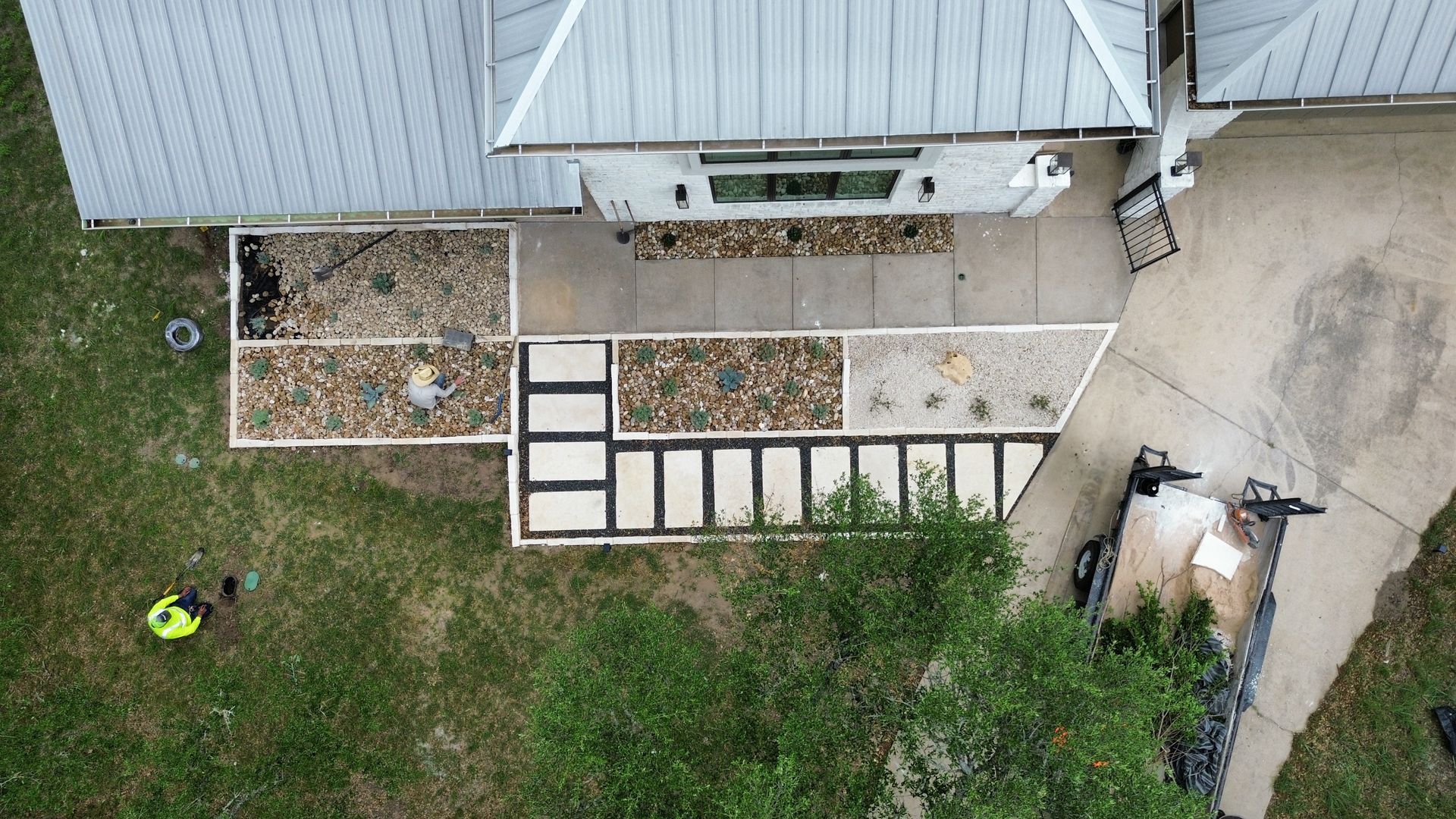 An aerial view of a house with a concrete walkway leading to it.