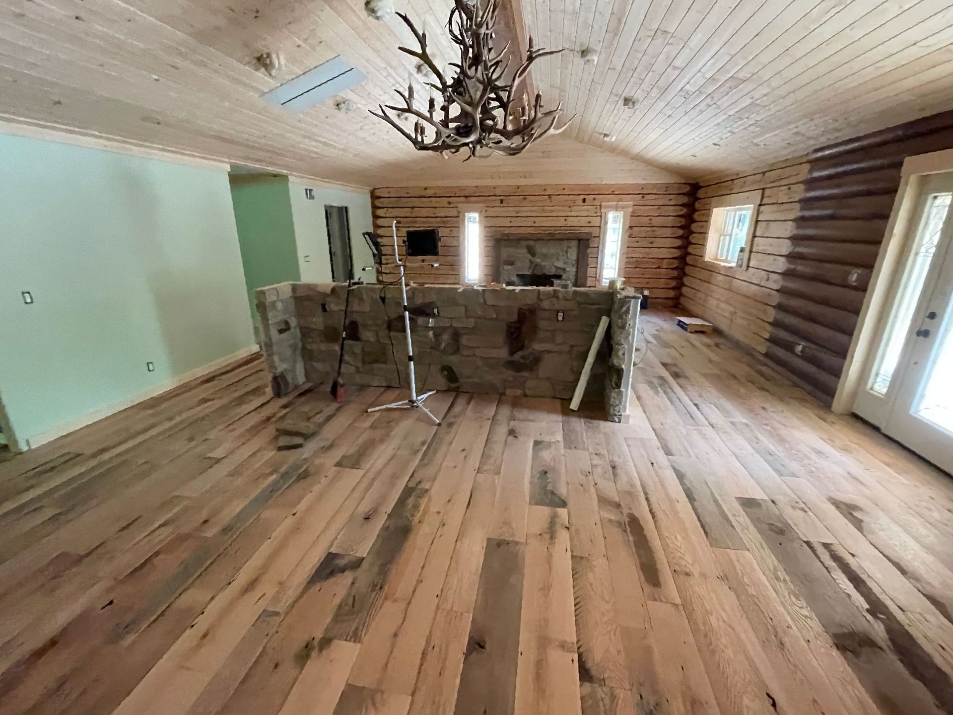 A living room with wooden floors and a fireplace.