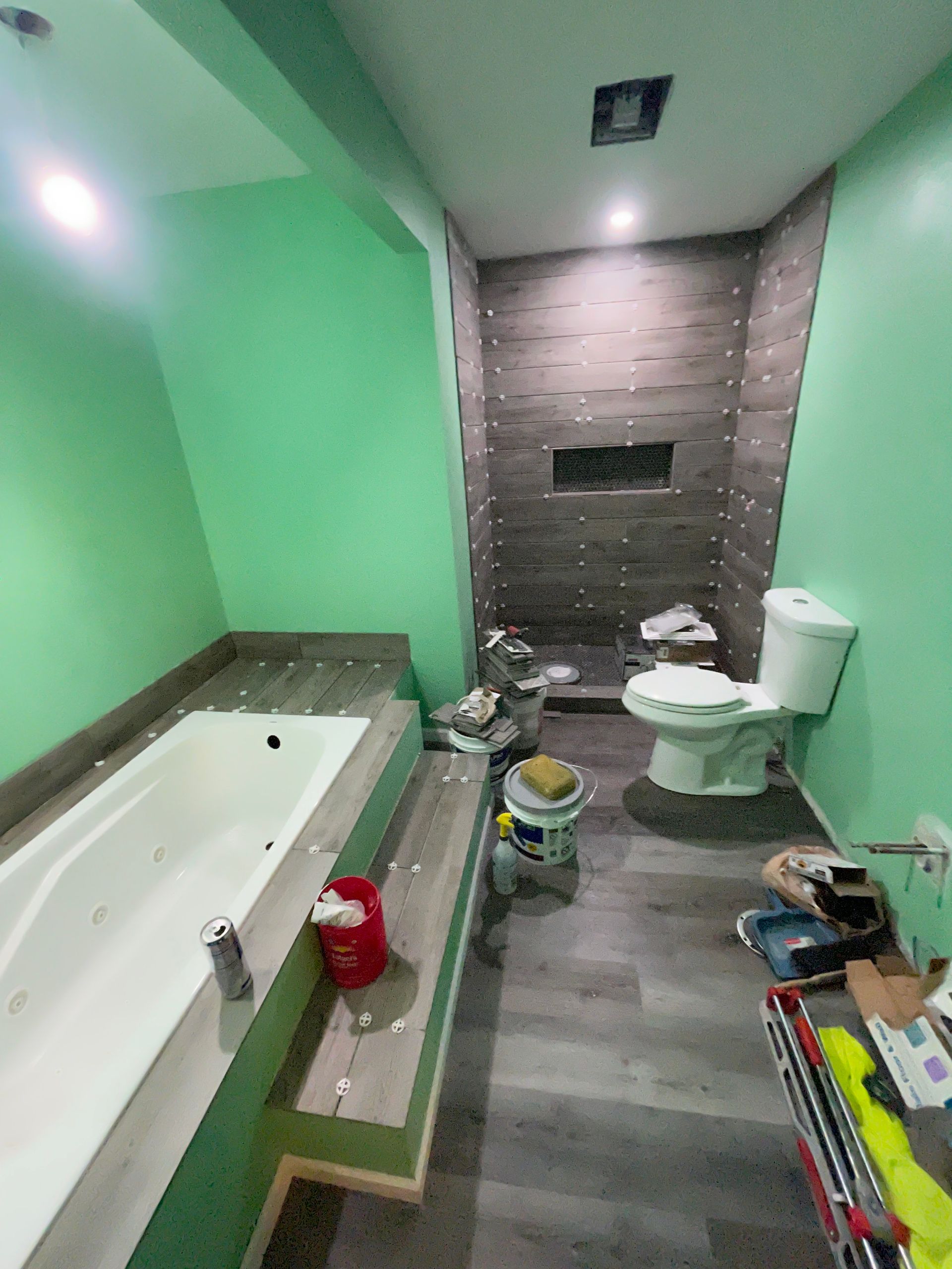 A room under construction with a ladder and a stool on the floor.