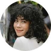 A woman with curly hair is smiling in a circle