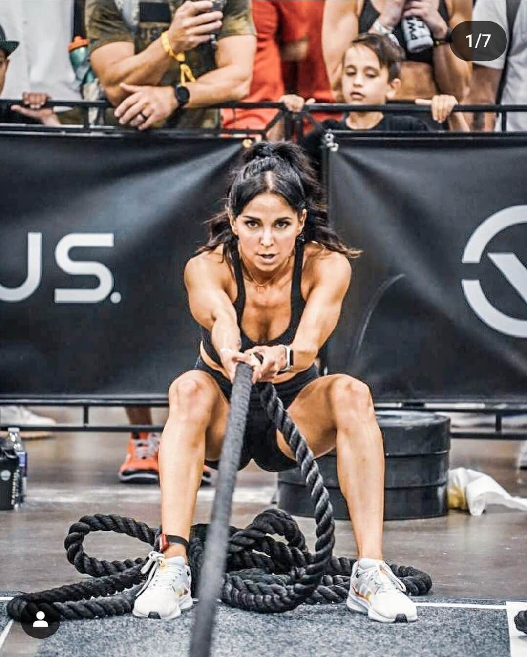 A woman is pulling a rope in front of a sign that says us