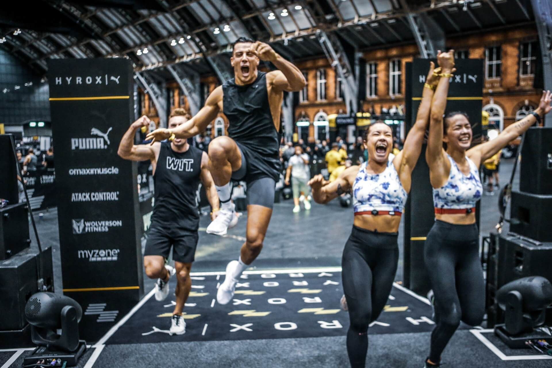A group of people are jumping in the air in a gym.