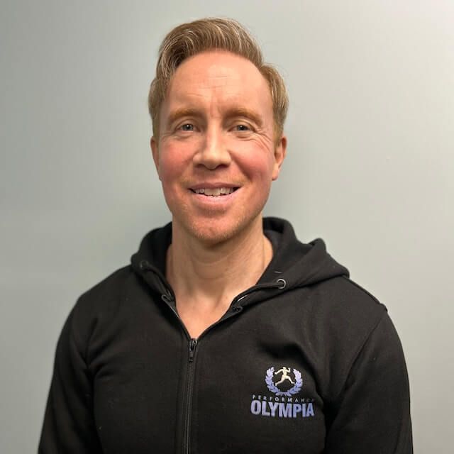 Steve Hoather wearing a black Olympia hoodie smiles for the camera
