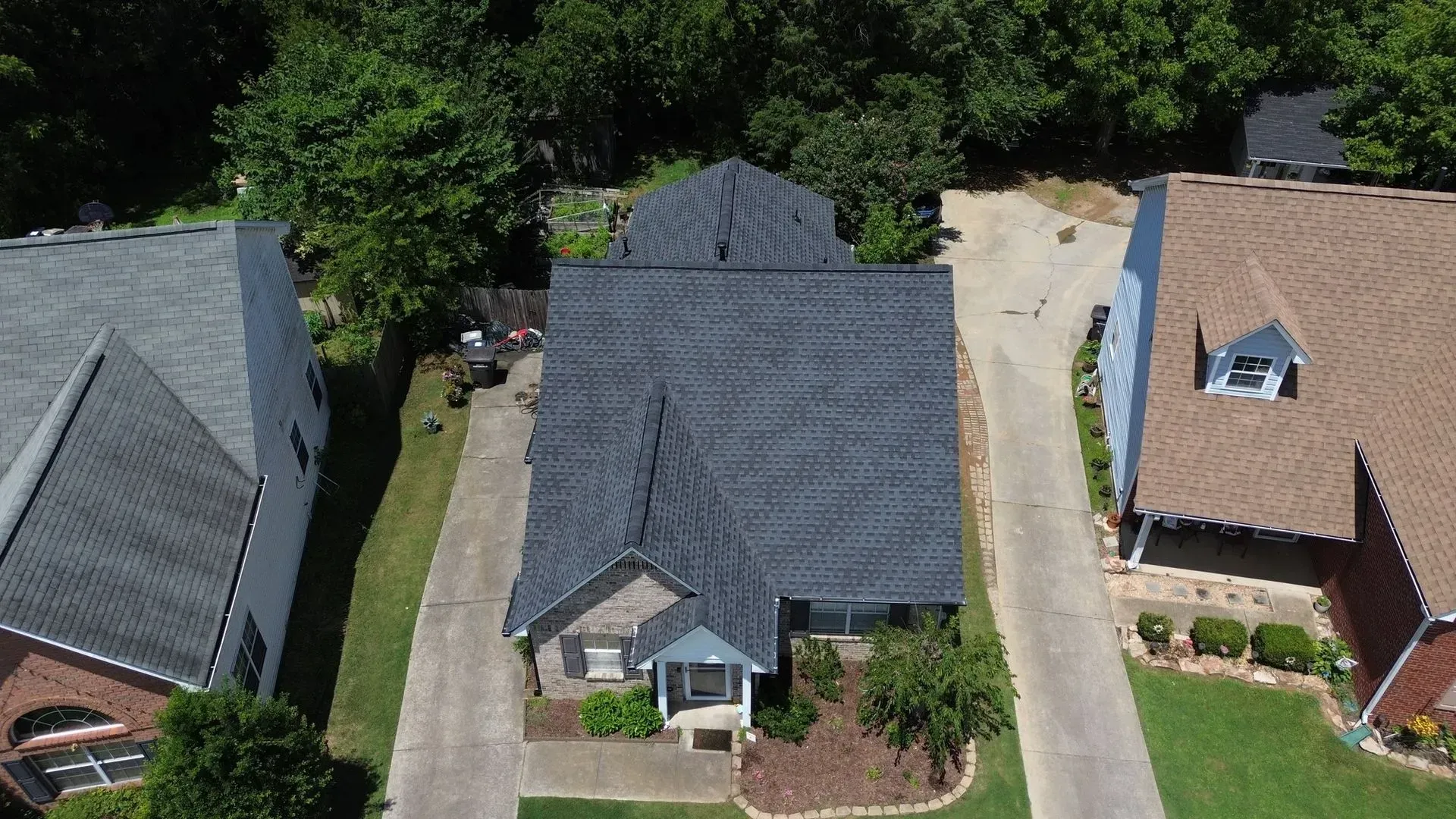 An aerial view of a house with a new roof in a residential area.