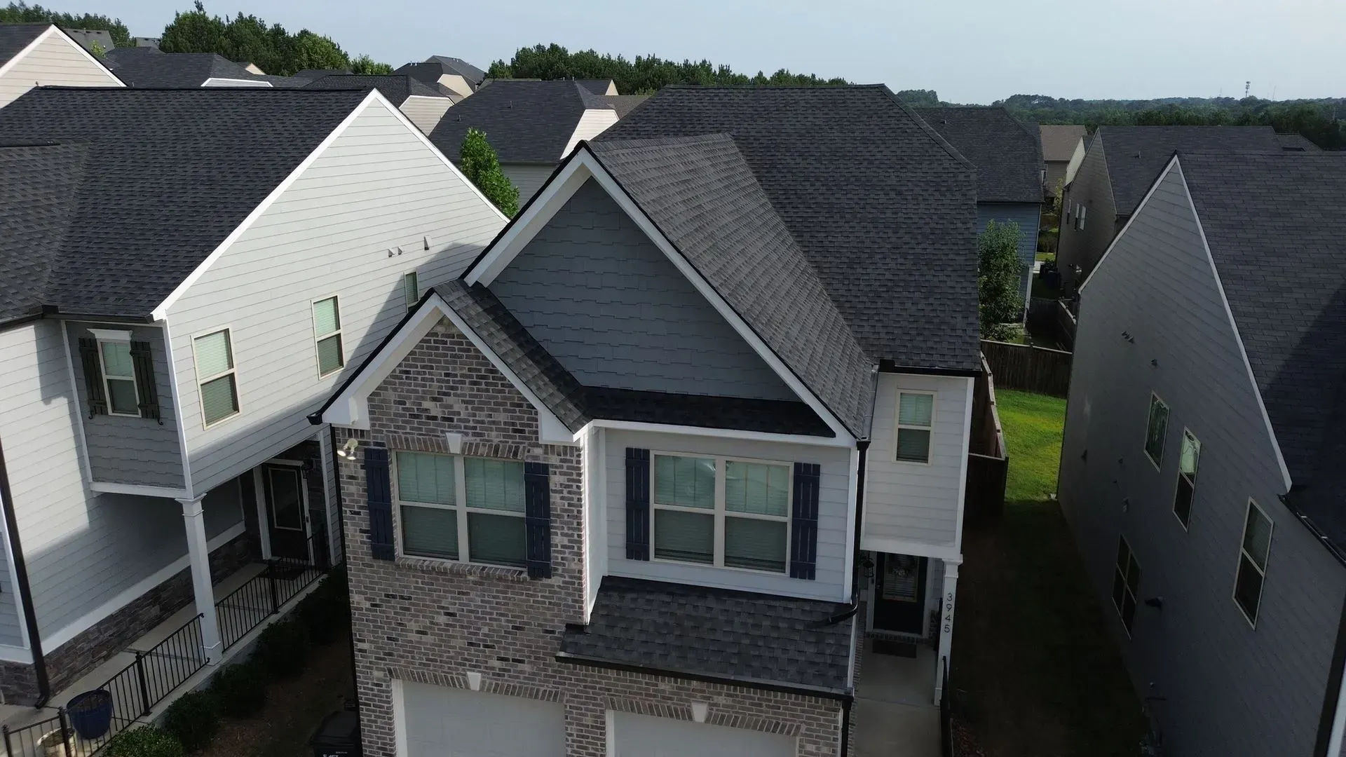 An aerial view of a row of houses with roofs that are being repaired.