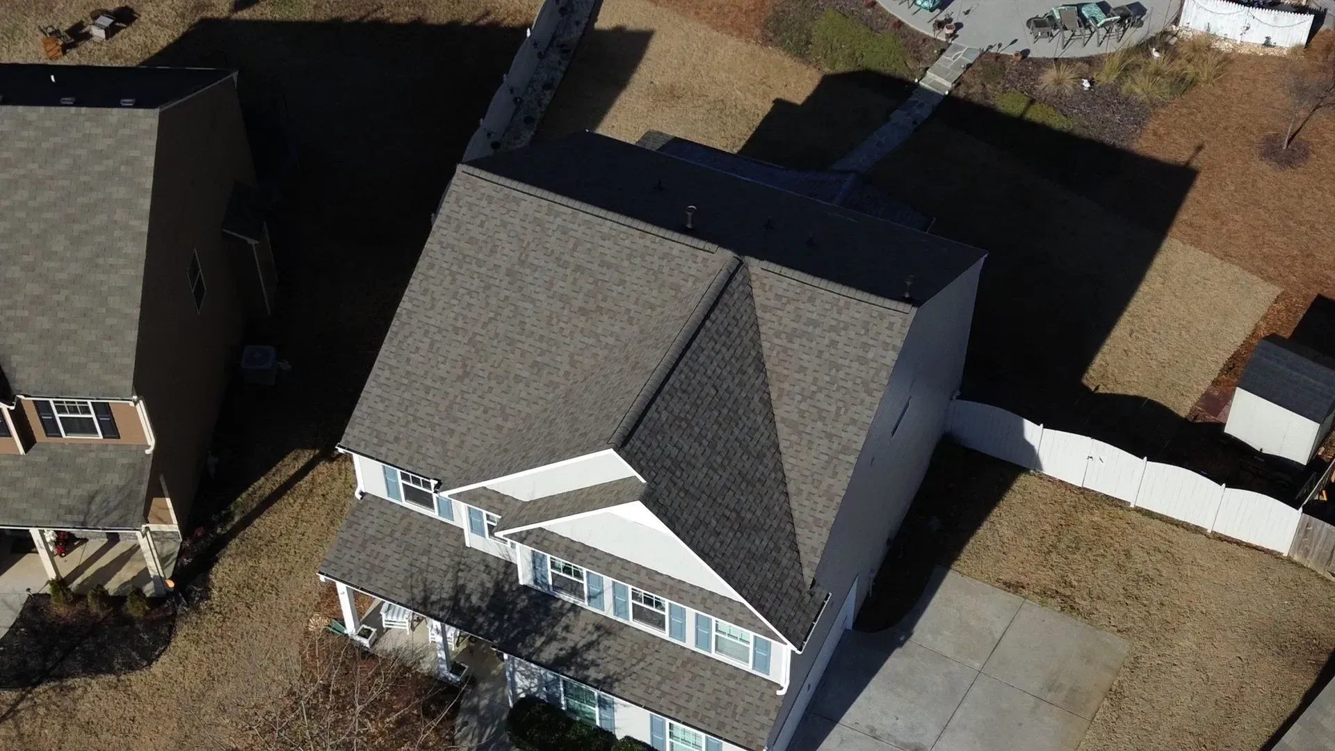 An aerial view of a house with a gray roof