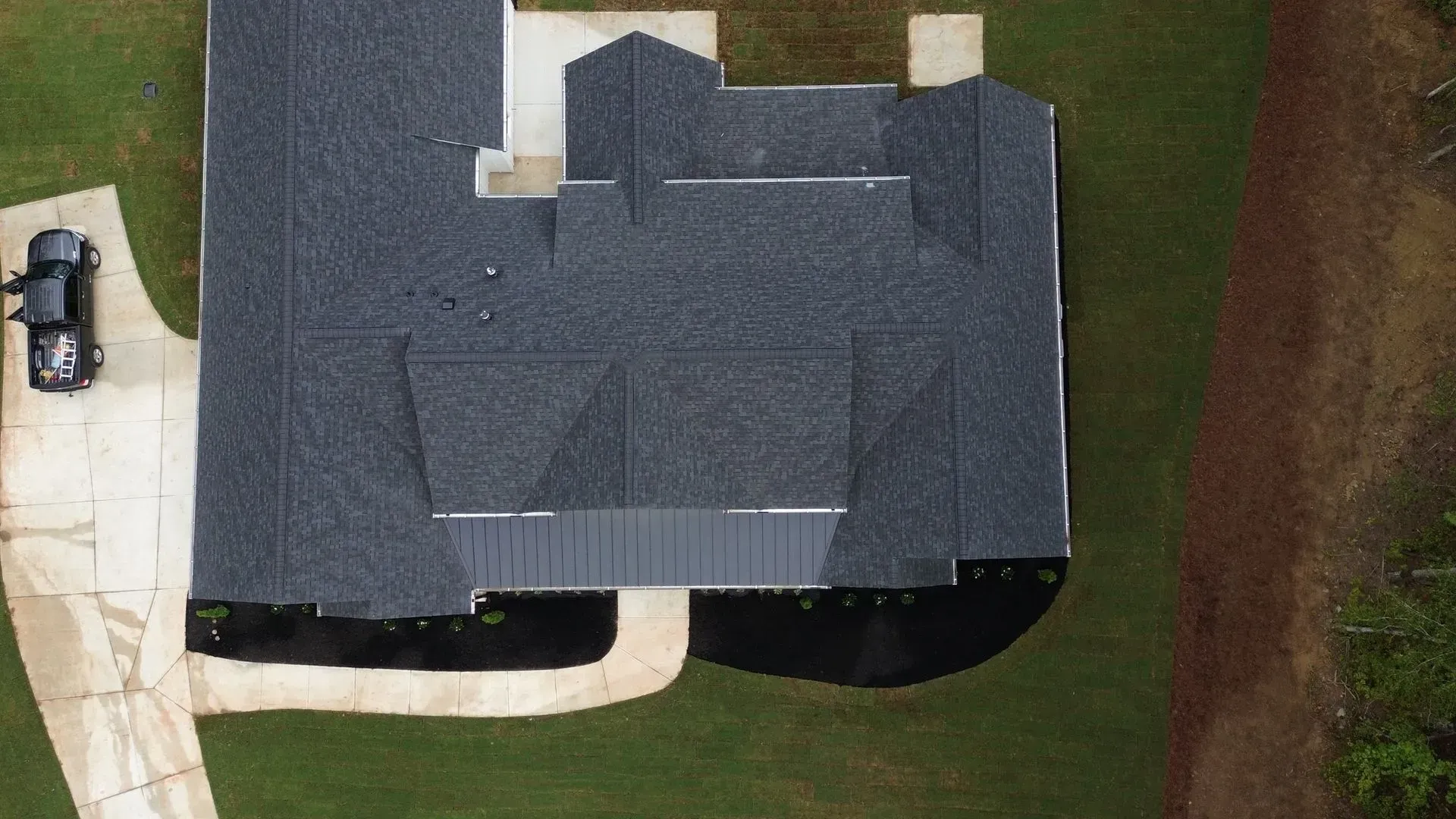 An aerial view of a house with a car parked in front of it.