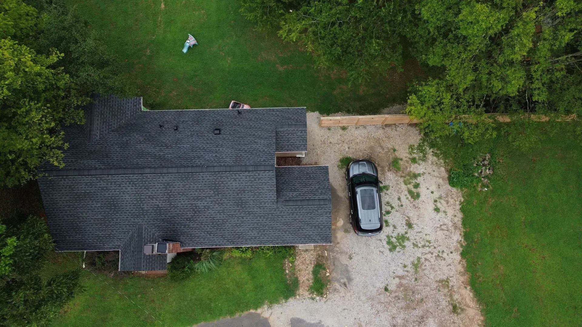 An aerial view of a house with a car parked in front of it.