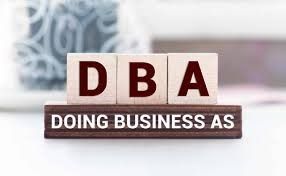 The word dba is written on wooden blocks on a table.