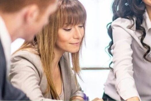 A group of people are sitting around a table having a meeting.