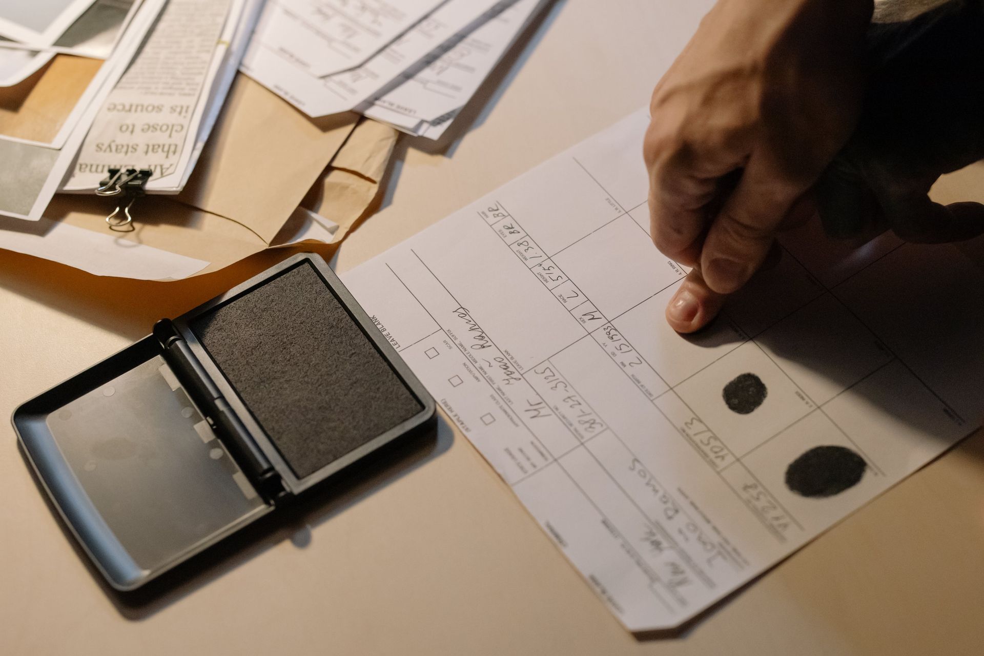 A person is stamping a fingerprint on a piece of paper