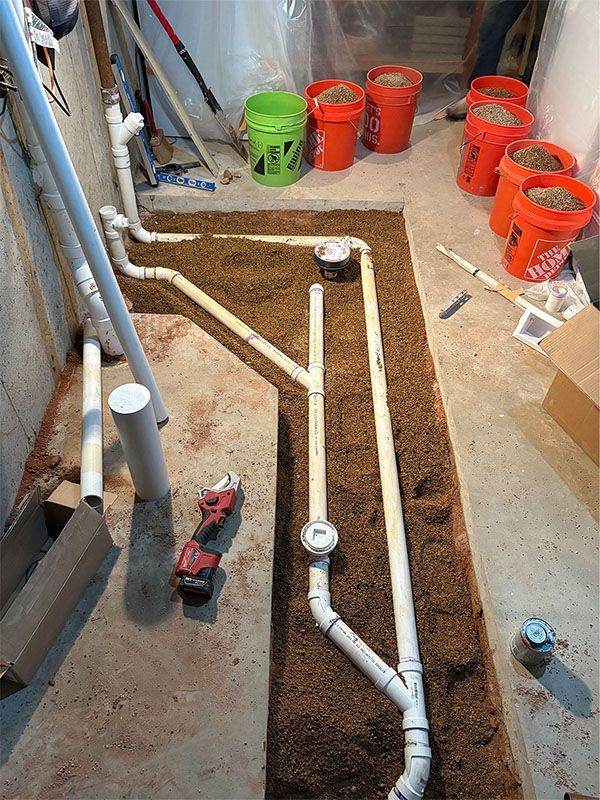 Two water heaters are hanging on a wall next to copper pipes.