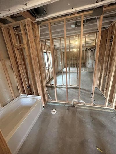 A bathroom in a house under construction with a bathtub.