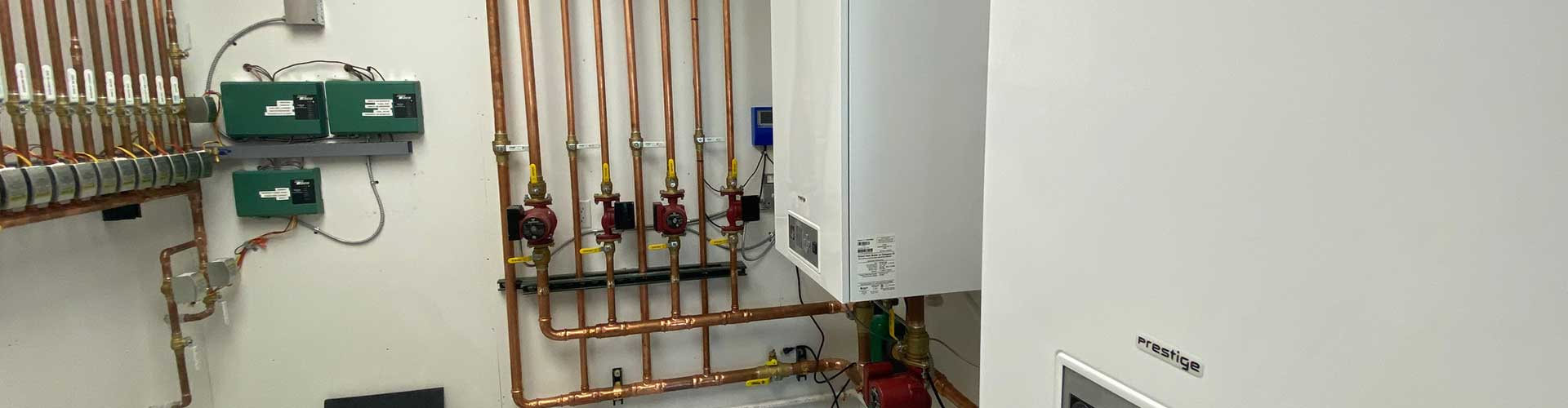 A water heater is sitting in a basement next to a wall.