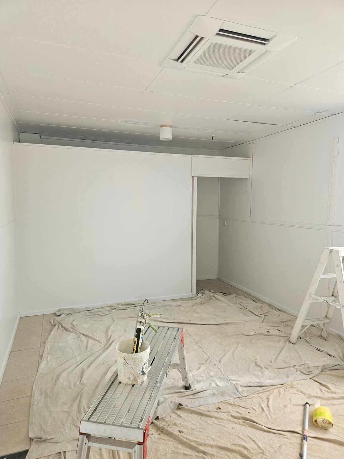 A Room With White Walls and a Ladder in It is Being Painted — Chops Painting in Coral Cove, QLD