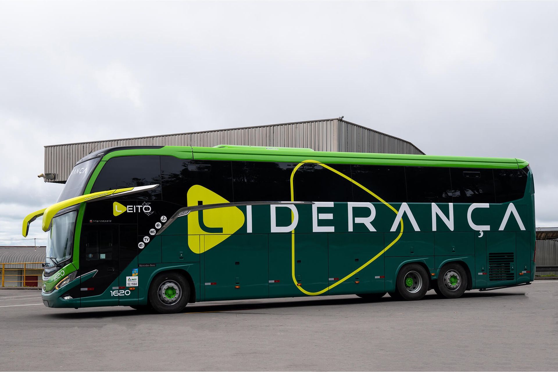 Ônibus Liderança verde e preto com logotipo amarelo, estacionado do lado de fora.