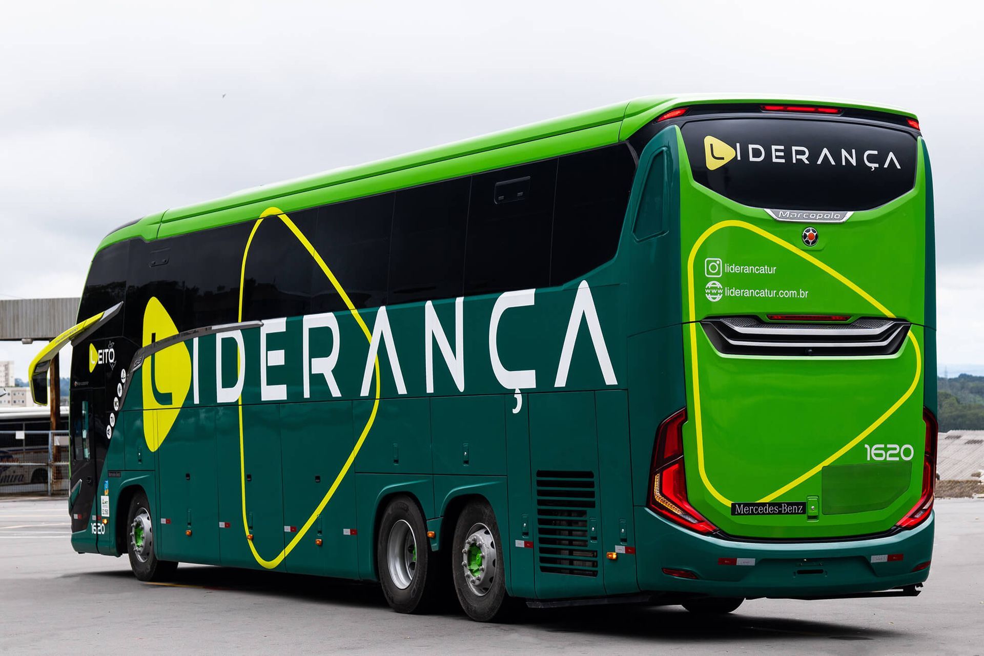 Ônibus Liderança verde com detalhes em amarelo. Vista externa.