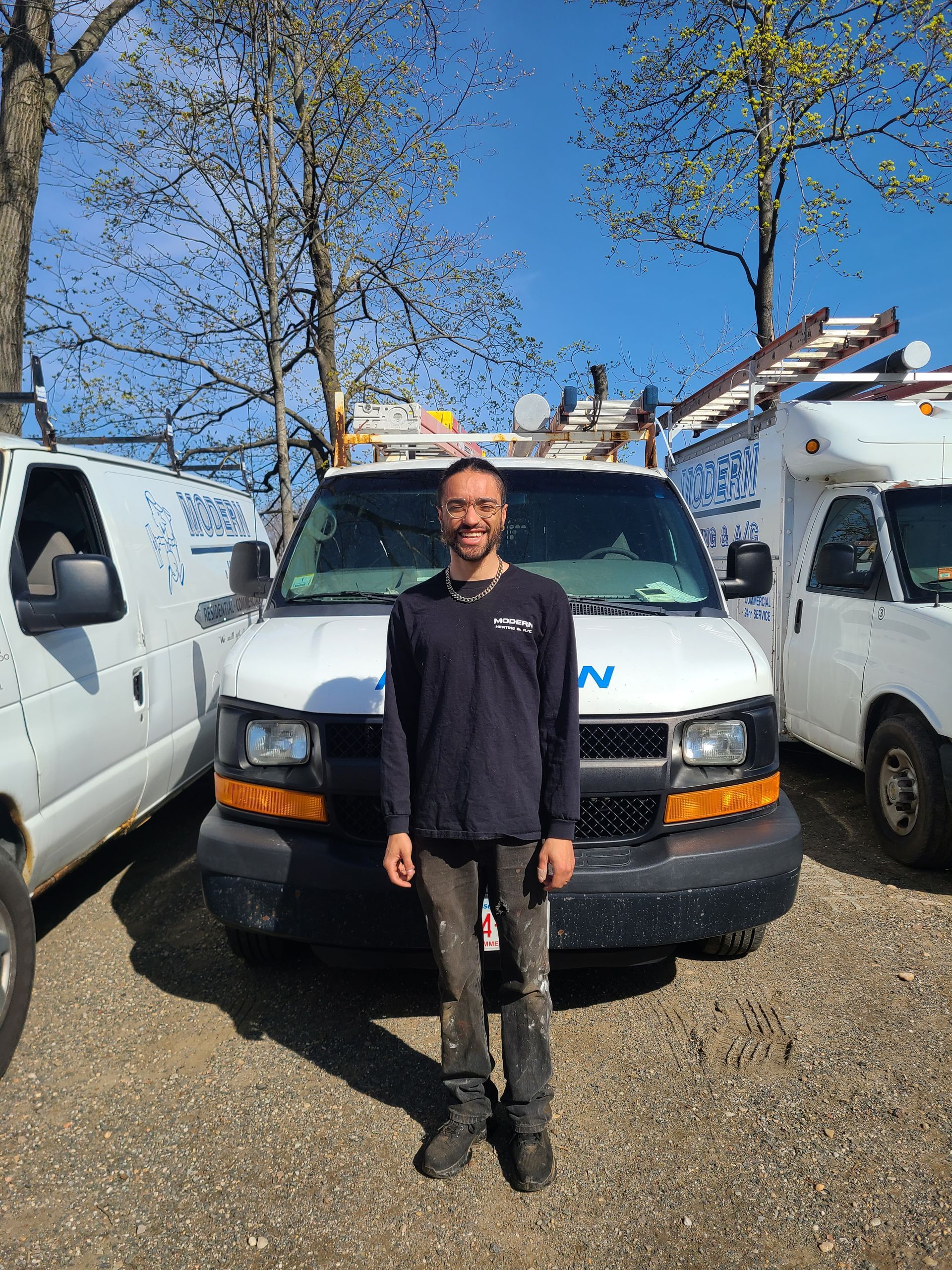 A man is standing in front of a van in a parking lot.