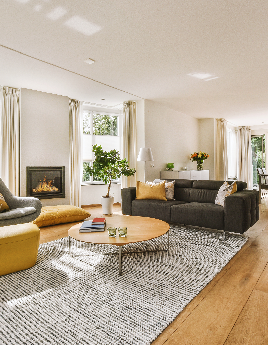 A living room with a couch , chair , coffee table and fireplace.