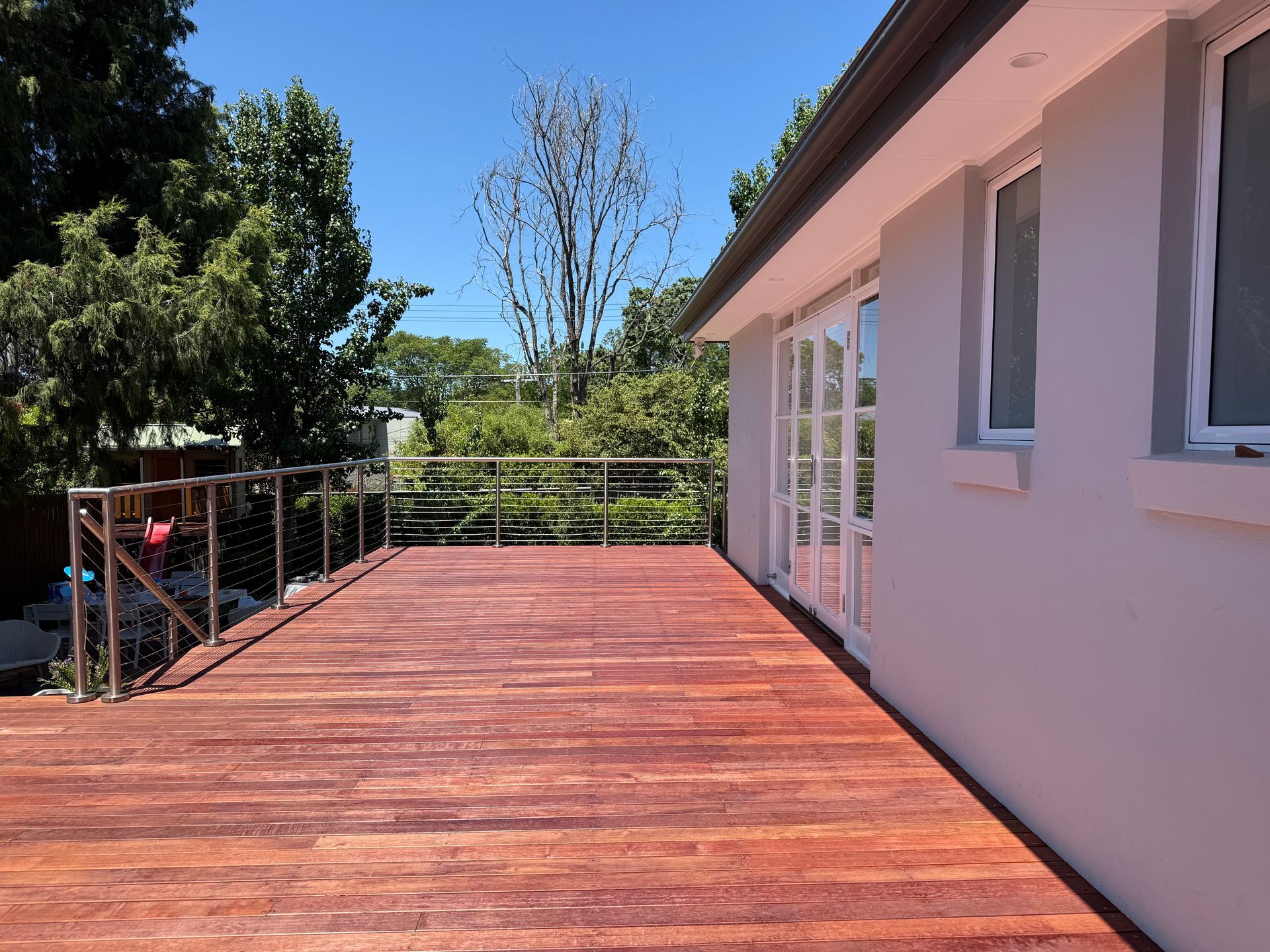 A white house with a wooden deck in front of it