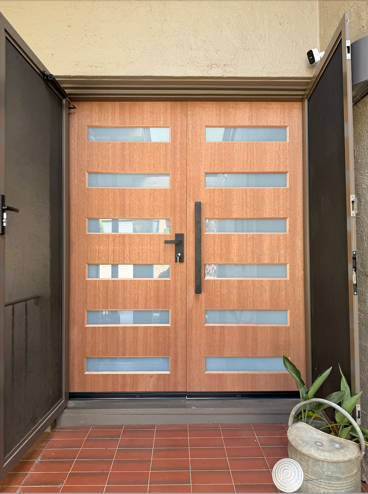 A brick building with a wooden door and a blue rug