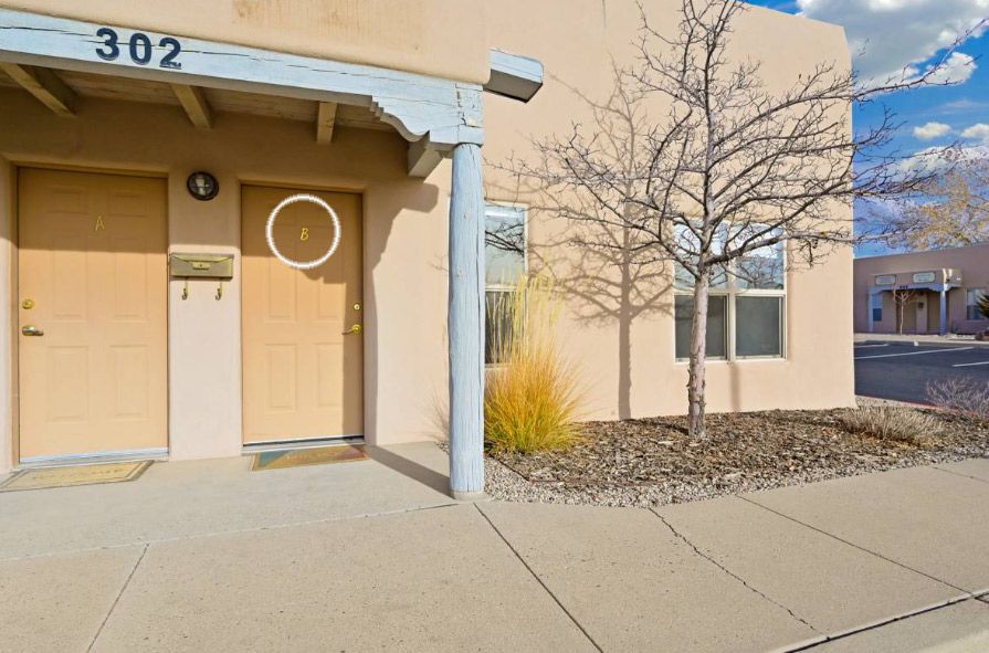 Tan stucco building with door and address 