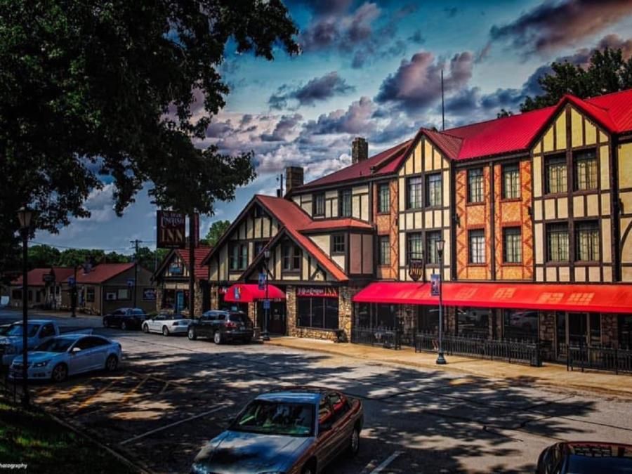 A row of buildings with red awnings are lined up in a parking lot.