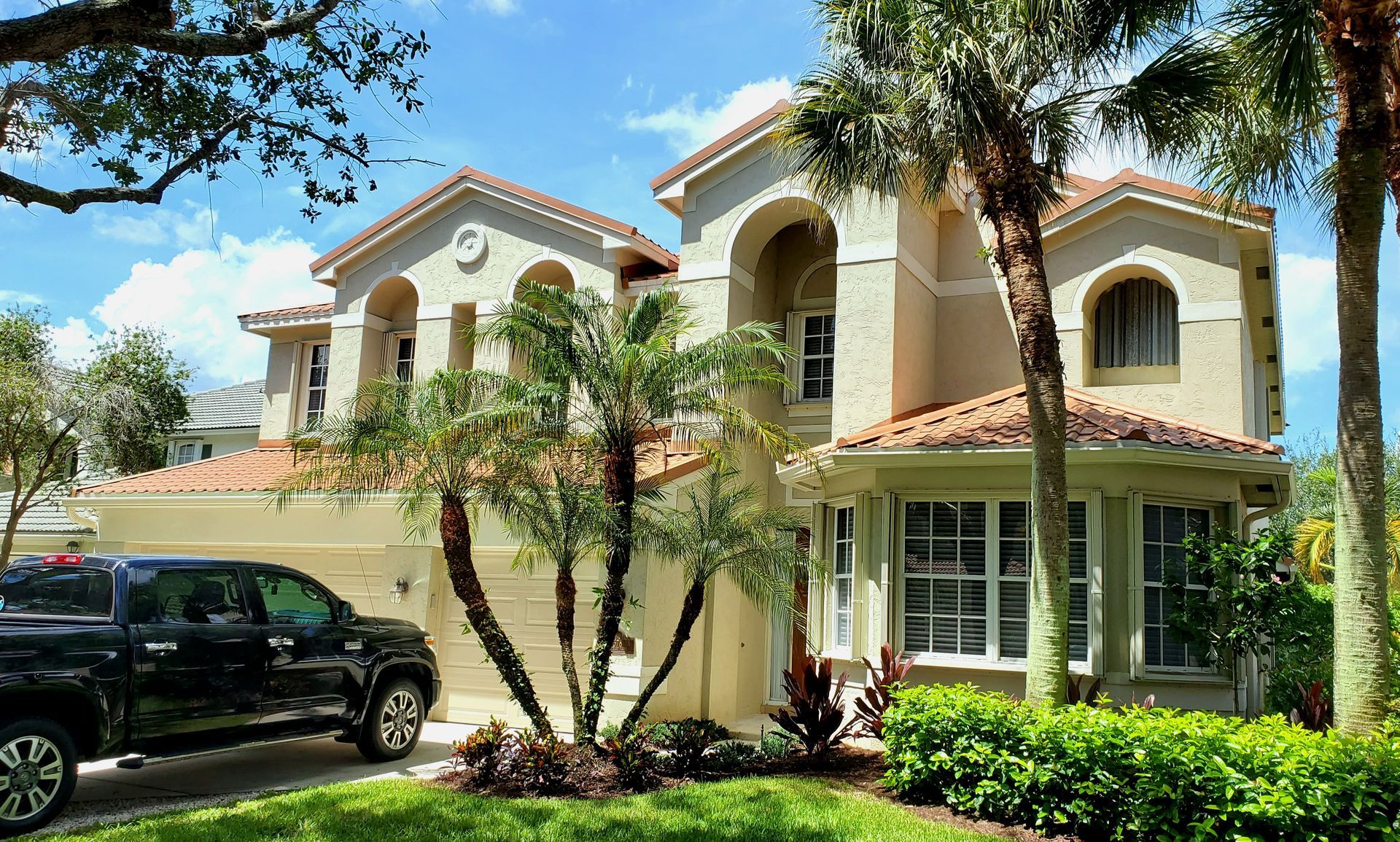 A large house with a black truck parked in front of it.