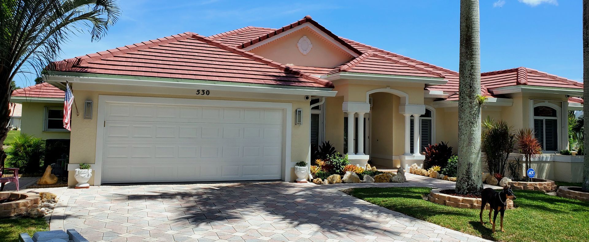 A large house with a red tile roof and a white garage door.