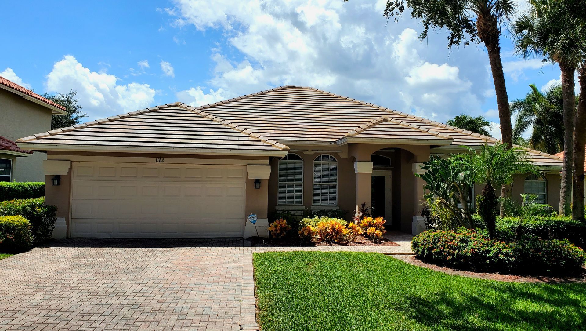 A house with a large garage and a brick driveway