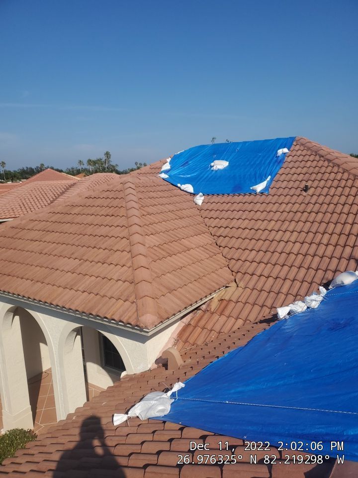 A blue tarp is covering the roof of a house