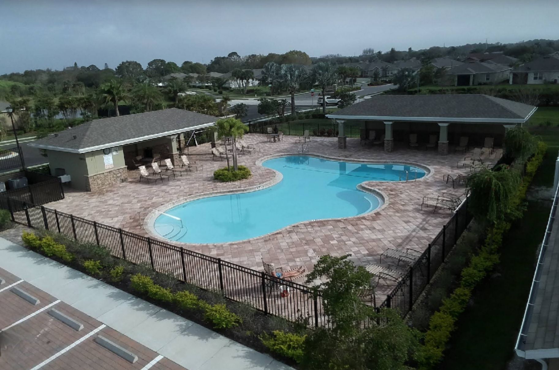An aerial view of a large swimming pool surrounded by a fence.