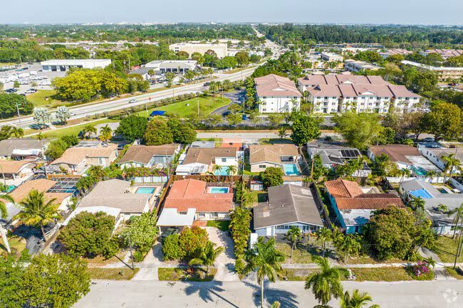 A sign for branson hills estates is sitting in the middle of a lush green field.