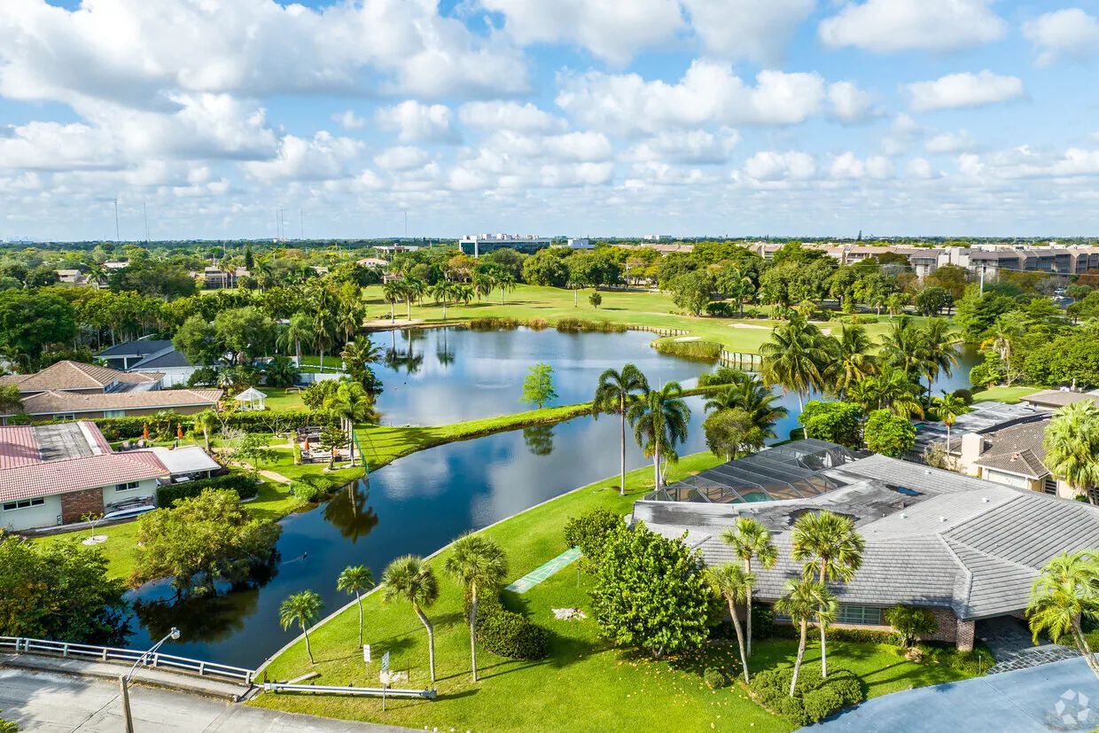 A sign for branson hills estates is sitting in the middle of a lush green field.