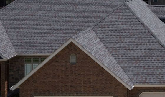 A close up of a brick house with a gray roof.