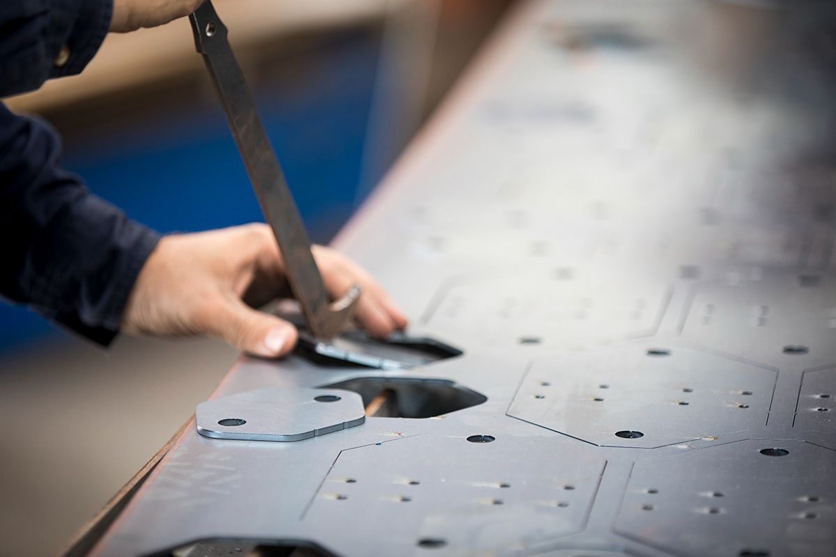A person is measuring a piece of metal with a ruler — Sheet Metal Fabrication In Caloundra, Qld